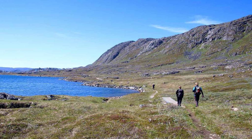 hiking_in_Greenland_during_summertime_alongside_the_ocean