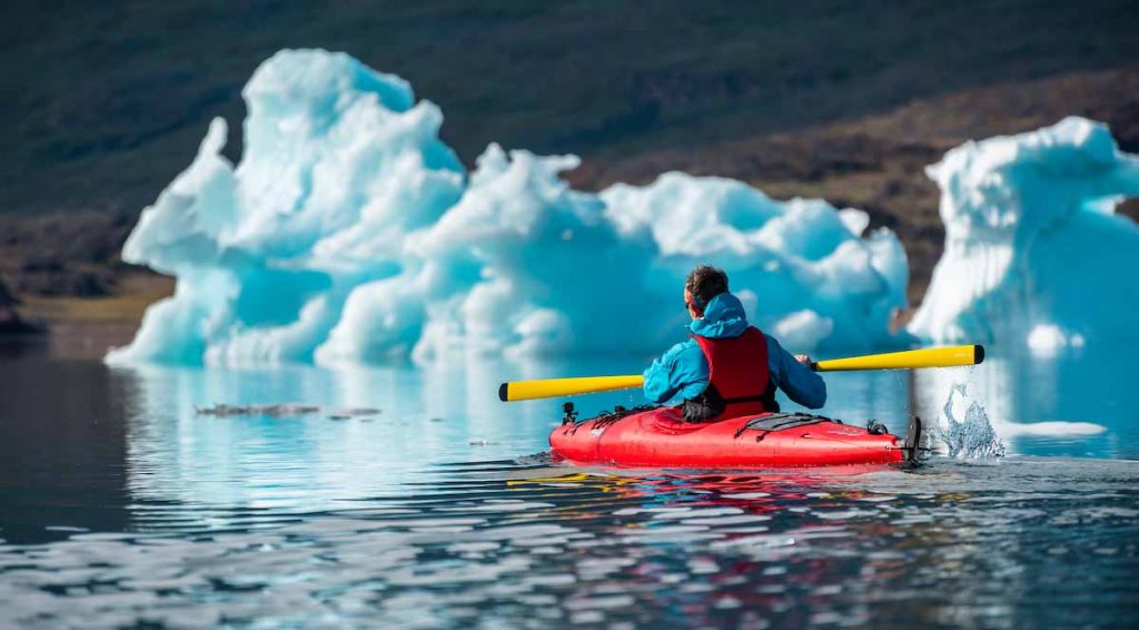 traveller_enjoys_kayaking_in_front_of_icebergs