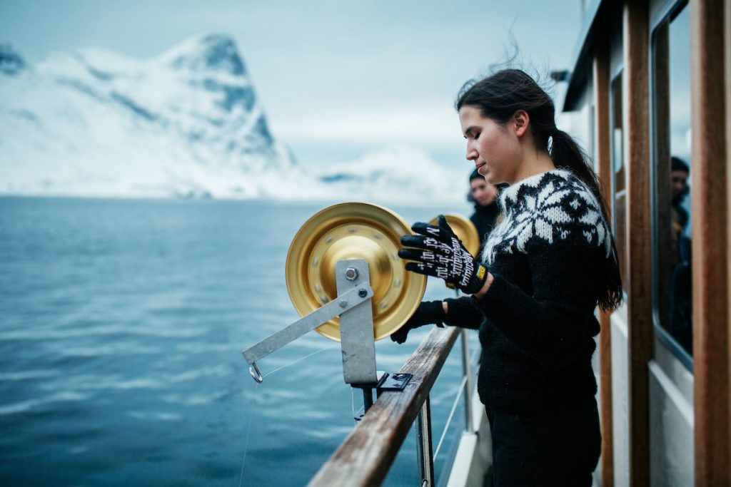 a_girl_pulling_out_fish_from_the_sea_fishing_tour_in_greenland