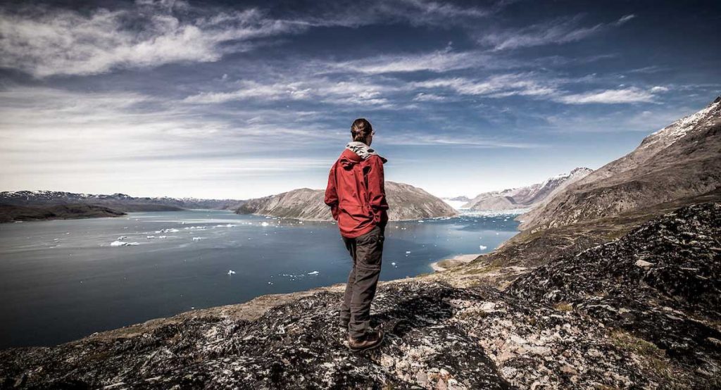 a_traveller_standing_on_the_top_of_a_mountain_in_narsarsuaq